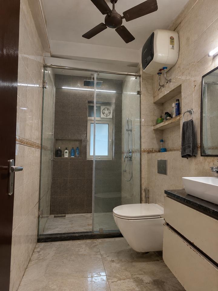 Bathroom with glass shower partition and wall-hung toilet – Sector 128 Noida bathroom renovation